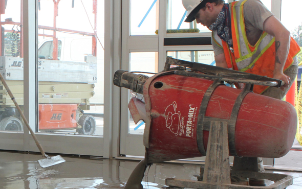 Pouring flooring materials during Milburn Flooring Prep Crew’s surface preparation for a smooth, level installation.