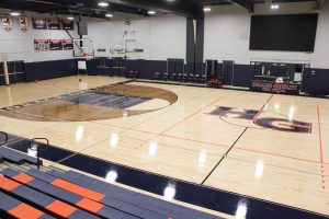 Bright, safe sports flooring with school logo and full colors, part of restoring existing sports flooring