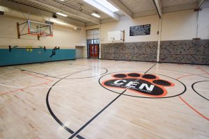 Customized multipurpose school gym with logo on durable, restored sports flooring
