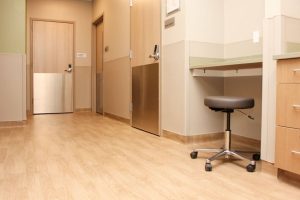 Patient care room with resilient wood flooring that supports healthcare flooring safety standards.