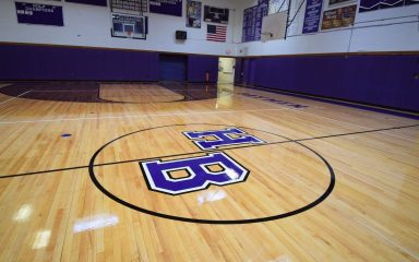 School gym featuring logo on safe, high-quality sports flooring restored for student use