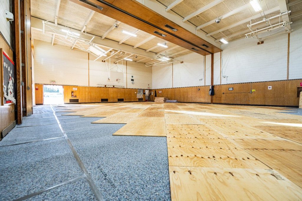 Professional gym floor refinishing in a school gym during a low-use period for better safety and performance