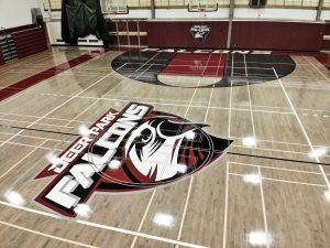 Newly refinished hardwood gym floor with slip-resistant surface ready for student athletes and community events