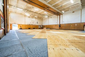 Professional gym floor refinishing in a school gym during a low-use period for better safety and performance