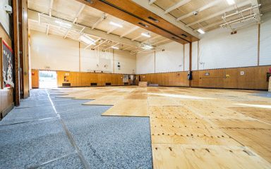 Professional gym floor refinishing in a school gym during a low-use period for better safety and performance